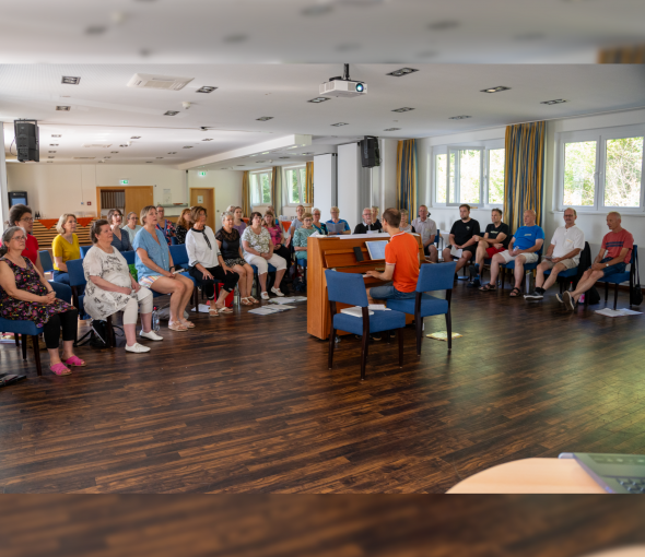 Chorgruppe im Tagungsraums Taunus mit Chorleiter am Klavier