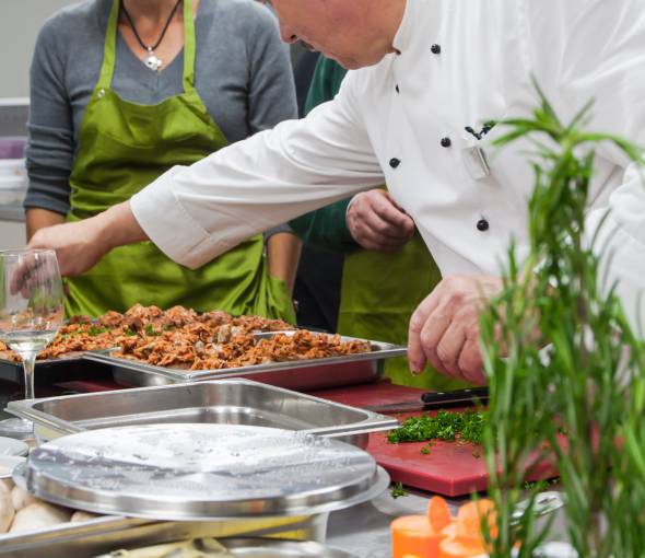 Koch des TaunusTagungsHotel beim Kochen mit der Kochgruppe