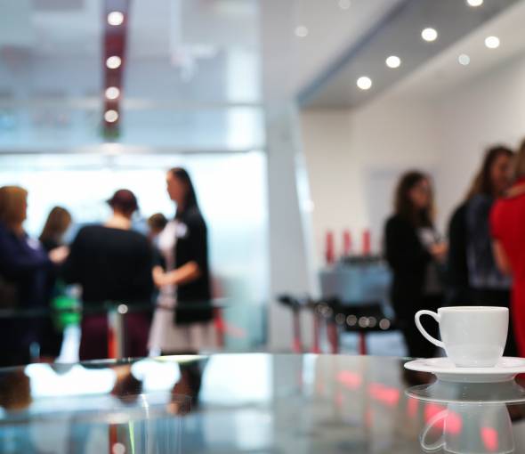 Kaffeepause im TaunusTagungsHotel mit Gästen im Hintergrund